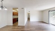 Located in Charlotte, NC, this single-floor, 2-bedroom, 2-bathroom home offers a well-designed layout with clean finishes throughout. The open living and dining area is anchored by a classic brick fireplace and features wood-look flooring that extends through much of the home. A sliding glass door floods the space with natural light and provides direct access to a private patio with outdoor views.

The galley-style kitchen is thoughtfully appointed with white shaker cabinetry, granite-look countertops, a stainless steel sink, and black appliances including a range, refrigerator, and dishwasher. A skylight overhead brightens the workspace naturally.

Both bedrooms are comfortably sized, with the primary bedroom offering generous closet space. The rooms maintain a neutral, light-filled aesthetic with wood-look flooring. Four closets throughout the home provide ample storage.

The two bathrooms are finished with granite-top vanities, framed mirrors, and brushed nickel fixtures. One bathroom includes a full tiled tub-shower combination. Additional conveniences include a dedicated laundry area and a utility room. The overall ambiance is clean, bright, and functional, making this home a practical and comfortable residence in Charlotte.