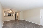 Located at 3101 N Midland Dr in Midland, Texas, this single-floor unit offers a well-organized layout with consistent wood-look flooring flowing throughout each room, providing a clean and cohesive aesthetic. The open living area is anchored by a ceiling fan with light fixture and a textured ceiling, creating a comfortable and functional gathering space. A pass-through counter connects the living area to the kitchen, which is equipped with black appliances including a microwave, stove, and refrigerator, complemented by gray cabinetry, light countertops, a stainless steel sink, and a dishwasher. The kitchen's efficient design maximizes workspace while maintaining an open connection to the main living area. The bedrooms are generously proportioned, each featuring wood-look flooring, textured ceilings, and windows dressed with horizontal blinds that allow natural light to fill the rooms. Neutral beige wall tones throughout the unit create a calm, versatile backdrop suitable for a variety of interior styles. Ceiling fans in multiple rooms promote comfortable airflow, and HVAC vents are present throughout for climate control. The six-panel interior doors add a traditional architectural detail, while clean white baseboards frame each room with a crisp finish.