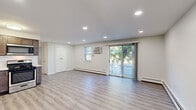Located at 9951 Academy Rd in Philadelphia, PA, this well-appointed one-bedroom, one-bathroom unit offers a thoughtfully designed layout across a single floor. The open-concept living and kitchen area is anchored by light gray wood-look flooring, recessed lighting, and a sliding glass door that fills the space with natural light and provides outdoor access. Baseboard heating runs throughout, complemented by wall-mounted air conditioning units for year-round comfort.

The kitchen is a standout feature, outfitted with rich dark-toned cabinetry, light quartz countertops, a white subway tile backsplash, and a full suite of stainless steel appliances including a gas range, built-in microwave, dishwasher, and French door refrigerator.

The generously sized bedroom is carpeted for warmth and comfort, featuring two windows with natural light, a wall-mounted AC unit, and double closet doors offering ample storage. A stacked washer and dryer unit is conveniently integrated into the bedroom area. The bathroom features large-format tile flooring, a tub/shower combo with crisp white tile surround, and a decorative mosaic accent border, completing this clean and functional space.
