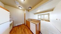 Located at 1201 E Helena Ave in Ellensburg, WA, this one-bedroom, two-bathroom residence offers a well-organized, single-floor layout designed for comfortable everyday living. The heart of the home is an open-concept space that seamlessly connects the kitchen, dining area, and living room. The kitchen features warm wood cabinetry, a dishwasher, a countertop with a built-in sink, and a peninsula that opens directly to the living and dining area — ideal for both cooking and entertaining. The living room is generously proportioned, finished with neutral carpet, and brightened by a bank of windows that allow natural light to fill the space. A door from the living area provides access to a private patio. The bedroom offers comfortable proportions, carpeted flooring, a sliding closet, and a window overlooking the outdoors. Additional storage is available through multiple closets throughout the unit. The two bathrooms include one with a full soaking tub and shower combination, with tile-style flooring throughout both. Baseboard heating runs throughout the unit, complemented by a wall-mounted HVAC unit. Neutral tones, wood-trimmed doors and accents, and a practical hallway layout complete this functional and inviting residence.
