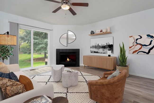 Sala de estar premium de Trentwood con pisos inspirados en tablones de madera y una chimenea a leña. - Camden Place