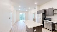 Located at 2451 Quincy Ave in Ogden, Utah, this thoughtfully designed single-floor residence offers two bedrooms, two bathrooms, and a functional, modern layout. The open-concept living, dining, and kitchen area serves as the heart of the home, featuring light wood-style flooring, recessed lighting, and a sliding glass door that invites natural light and outdoor views. The contemporary kitchen is equipped with dark wood-grain cabinetry, a white quartz countertop island, stainless steel appliances including a refrigerator, gas range, and dishwasher, along with open shelving and an under-mount sink. Both bedrooms are bright and comfortable, with large windows fitted with blinds and continued light flooring throughout. The primary bedroom offers generous dimensions with its own closet. Two walk-in or wall closets provide ample storage with double hanging rods. The bathrooms feature light, clean finishes — one includes a tub-shower combo, while the other is equipped with accessibility grab bars, offering added functionality and inclusivity. A dedicated laundry area houses a full-size side-by-side washer and dryer. Clean white walls and consistent flooring throughout lend the space a cohesive, modern aesthetic.