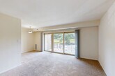 Located at 2110 Brooks Dr in District Heights, MD, this one-bedroom, one-bathroom residence offers a practical and well-organized single-floor layout. The entrance opens onto tile flooring and leads directly into a bright, open living room carpeted throughout and anchored by large sliding glass doors that provide access to a private balcony with outdoor views of surrounding greenery and the parking area. A pendant light fixture adds a functional accent to the space. The kitchen is efficiently designed with light maple cabinetry, dark granite-style countertops, tile flooring, and a full suite of black appliances including a gas range, dishwasher, and refrigerator, along with an overhead microwave and double-basin sink. The bedroom is a comfortable, carpeted room featuring a window with natural light, a dedicated closet, and ceiling ventilation. The bathroom includes a full tub-shower combination with neutral tile surround and chrome fixtures. Soft, neutral tones and carpet flooring run throughout the living spaces, creating a cohesive and low-maintenance environment. The layout also includes a closet for additional storage, making efficient use of the available space throughout the home.