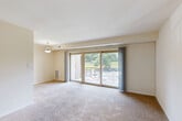 Located at 2110 Brooks Dr in District Heights, MD, this one-bedroom, one-bathroom residence offers a practical and well-organized single-floor layout. The entrance opens onto tile flooring and leads directly into a bright, open living room carpeted throughout and anchored by large sliding glass doors that provide access to a private balcony with outdoor views of surrounding greenery and the parking area. A pendant light fixture adds a functional accent to the space. The kitchen is efficiently designed with light maple cabinetry, dark granite-style countertops, tile flooring, and a full suite of black appliances including a gas range, dishwasher, and refrigerator, along with an overhead microwave and double-basin sink. The bedroom is a comfortable, carpeted room featuring a window with natural light, a dedicated closet, and ceiling ventilation. The bathroom includes a full tub-shower combination with neutral tile surround and chrome fixtures. Soft, neutral tones and carpet flooring run throughout the living spaces, creating a cohesive and low-maintenance environment. The layout also includes a closet for additional storage, making efficient use of the available space throughout the home.