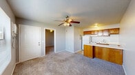 This 370 square foot apartment in Sand Springs, Oklahoma offers a practical living solution in a compact space. The single-story layout features one bedroom, measuring 110 square feet, ideal for a queen-sized bed and essential furniture. The living area is adorned with neutral-toned carpeting, providing warmth and comfort underfoot. Light gray walls throughout create a sense of openness and brightness.

The kitchen, though compact, is fully equipped with essential appliances including a refrigerator, stove, and dishwasher. Warm wood cabinetry adds a touch of classic style, while a small breakfast bar offers additional counter space and casual dining. The bathroom features a standard tub-shower combination with a practical grab bar for safety.

Lighting is provided by ceiling-mounted fixtures, including a fan in the main living area for improved air circulation. The apartment includes a closet for storage, and a window in the bedroom allows for natural light. Despite its modest size, the thoughtful layout maximizes the available space, making it suitable for single occupants or those embracing a minimalist lifestyle. Located at 811 E Pecan St, this apartment combines functionality with affordability in a convenient Sand Springs location.
