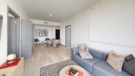 Located at 915 Division St in Nashville, TN, this single-floor unit offers four bedrooms and three bathrooms within a well-organized, modern layout. The open-plan living and dining area is anchored by expansive floor-to-ceiling windows with sliding glass doors, flooding the space with natural light and offering elevated views of the Nashville skyline. Light hardwood flooring runs throughout, lending warmth and continuity across the unit.

The kitchen is outfitted with dark flat-front cabinetry, white quartz countertops, a white subway tile backsplash, and stainless steel appliances, including a range, built-in microwave, and dishwasher. A hallway connects the kitchen to the bedroom wing, providing a clear and functional circulation path.

The primary bedroom features a floor-to-ceiling window with city views and a clean, minimalist aesthetic. Additional bedrooms maintain the same light-filled, neutral character. Two closets provide dedicated storage within the unit.

The three bathrooms are finished in a consistent contemporary style, each featuring large-format tile, frameless or black-framed glass shower enclosures, floating vanities, and matte black hardware, creating a cohesive, upscale feel throughout.