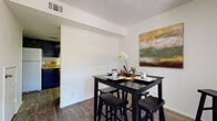 This two-floor residence is thoughtfully laid out to maximize functionality across its living spaces. The living room provides a comfortable gathering area finished with wood-look plank flooring, neutral walls, and a textured ceiling, creating a clean and understated ambiance. Adjacent to the living room, the dedicated dining area accommodates a full dining set and is open to the kitchen, making it well-suited for everyday meals and entertaining.

The galley-style kitchen features dark cabinetry contrasted by granite-look countertops and white appliances, including a range, dishwasher, and over-the-range microwave. The efficient linear layout optimizes counter and storage space. A dedicated laundry room houses a full-size washer and dryer, adding notable convenience.

The bathrooms are consistently finished with dark vanity cabinetry, granite-look countertops, large mirrors, and wood-look flooring, lending a cohesive aesthetic throughout. The bedrooms are carpeted for comfort and include ceiling fans and windows that allow natural light, contributing to a restful atmosphere. Overall, the residence offers a practical and consistent design with matching finishes that unify the space across both floors.