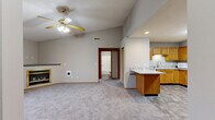 Located at 2303 Gen Electric Rd in Bloomington, Illinois, this 2-bedroom, 2-bathroom single-floor home offers a practical and comfortable layout. The living room is a standout feature, boasting vaulted ceilings, a ceiling fan, plush carpet, and a gold-framed gas fireplace that serves as a focal point. A window provides natural light and views of the surrounding landscape. The kitchen is well-appointed with warm oak cabinetry, granite-look countertops, stone-tile flooring, and stainless steel appliances including a range and dishwasher. A peninsula counter connects the kitchen to the main living area, creating an open, functional flow. Both bedrooms are carpeted and equipped with ceiling fans. The primary bedroom features vaulted ceilings and includes a closet, while the second bedroom benefits from a large window with outdoor views. The two bathrooms are finished with stone-tile flooring, oak vanities, and granite-look countertops; one includes a full tub/shower combo. Additional highlights include six closets for generous storage, an in-unit laundry area, and a connecting hallway that ties the layout together efficiently. The neutral color palette throughout lends a clean, move-in-ready feel to the entire home.