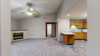 Located at 2303 Gen Electric Rd in Bloomington, Illinois, this 2-bedroom, 2-bathroom single-floor home offers a practical and comfortable layout. The living room is a standout feature, boasting vaulted ceilings, a ceiling fan, plush carpet, and a gold-framed gas fireplace that serves as a focal point. A window provides natural light and views of the surrounding landscape. The kitchen is well-appointed with warm oak cabinetry, granite-look countertops, stone-tile flooring, and stainless steel appliances including a range and dishwasher. A peninsula counter connects the kitchen to the main living area, creating an open, functional flow. Both bedrooms are carpeted and equipped with ceiling fans. The primary bedroom features vaulted ceilings and includes a closet, while the second bedroom benefits from a large window with outdoor views. The two bathrooms are finished with stone-tile flooring, oak vanities, and granite-look countertops; one includes a full tub/shower combo. Additional highlights include six closets for generous storage, an in-unit laundry area, and a connecting hallway that ties the layout together efficiently. The neutral color palette throughout lends a clean, move-in-ready feel to the entire home.