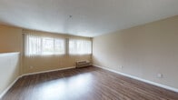 Located at 1425 NE Seventh Ave in Portland's vibrant NE neighborhood, this single-floor unit offers a functional and comfortable layout designed for everyday living. The spacious living area is highlighted by warm hardwood-style flooring, neutral-toned walls, and a bank of windows fitted with vertical blinds that invite generous natural light. A wall-mounted HVAC unit ensures year-round climate comfort. The galley-style kitchen is efficiently arranged with light wood cabinetry, dark countertops, a stainless steel sink, and a full suite of appliances including a gas range, microwave, dishwasher, and refrigerator — all set over easy-care hard flooring. A dedicated bedroom features plush carpeting, a ceiling fan with light fixture, and a large closet for ample storage. The bathroom offers a clean, straightforward layout with a combination tub and shower, toilet, and tile-style flooring. Textured ceilings throughout lend a classic character to the space, while the open sightlines between the kitchen, hallway, and living area create a connected, cohesive feel. This unit provides a practical and comfortable living environment in a well-established Portland location.