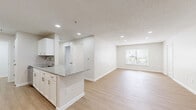 Located at 2423 Martin Luther King Dr in Atlanta, GA, this single-floor, 2-bedroom, 2-bathroom residence offers a well-organized and functional layout. The open kitchen and living area is a standout feature, showcasing granite countertops with an integrated sink, white shaker cabinetry, a subway tile backsplash, and stainless steel appliances including a range and refrigerator. Light wood-look flooring runs throughout the main living and kitchen areas, lending a clean and contemporary feel. The living room receives natural light through a window with blinds and is equipped with recessed lighting overhead. Both bedrooms are carpeted and finished with neutral tones; the primary bedroom offers a comfortable, well-proportioned footprint, while the secondary bedroom also features a window that brings in natural light. Each bathroom includes a full tub-shower combination with white tile surrounds and brushed nickel fixtures. Additional conveniences include two closets for ample storage and a dedicated laundry area. The overall aesthetic is modern and move-in ready, with a cohesive palette of neutral walls, white trim, and updated finishes throughout.