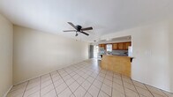 Located at 1810 S Oregon Ave in Weslaco, Texas, this single-story 2-bedroom, 1-bathroom unit offers a practical and comfortable layout. The open-concept living area is finished with light ceramic tile flooring and features a ceiling fan with light kit, creating a bright and airy atmosphere. The space flows directly into the kitchen, which is equipped with warm wood-toned cabinetry, a tile backsplash, a white electric range, a full-size refrigerator, and a double sink. A peninsula breakfast bar connects the kitchen to the living area, providing additional counter space and casual seating. Both bedrooms are finished with the same tile flooring and include ceiling fans and windows that allow natural light to fill the rooms. The primary bedroom includes built-in closet storage, offering practical organization space. The bathroom is appointed with a vanity, a tiled tub-and-shower combination featuring a bold marble-style surround, and tile flooring. A dedicated entrance leads into the unit, completing the functional single-floor layout. The neutral color palette throughout gives the space a clean, versatile feel suited to a variety of décor styles.