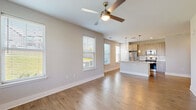 This single-story, 2-bedroom, 2-bathroom home features a thoughtfully designed open-concept layout that seamlessly connects the living room and kitchen. The living area is finished with warm hardwood-style flooring, neutral toned walls, and multiple windows that flood the space with natural light, complemented by a ceiling fan overhead. A glass door provides direct outdoor access, enhancing the bright and airy ambiance.

The kitchen is outfitted with contemporary wood-toned cabinetry, granite countertops, a center island, stainless steel appliances including a gas range and refrigerator, a tile backsplash, and stylish pendant lighting — making it both functional and visually appealing.

Both bedrooms feature plush carpeting, ceiling fans, and generous windows with outdoor views. Each bedroom is served by its own closet with built-in wire shelving for organized storage. The primary bathroom includes a dual-sink vanity with granite countertops, wood-toned cabinetry, a soaking tub, and direct access to a walk-in closet with multi-tier shelving.

Throughout the home, clean lines, consistent neutral finishes, and an abundance of natural light create a cohesive, modern aesthetic that is both comfortable and functional.