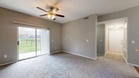 Located on River Oaks Drive in Columbus, Ohio, this single-floor, two-bedroom, two-bathroom home offers a well-organized layout designed for comfortable everyday living. The spacious living room is highlighted by plush carpeting, a ceiling fan with light fixture, and a sliding glass door that opens to a private patio, filling the space with natural light and outdoor views. The open-concept kitchen connects seamlessly to the dining area via a breakfast bar with dark countertops, dark cabinetry, hardwood-style flooring, and stainless steel appliances, making it ideal for both cooking and entertaining. The primary bedroom is generously sized with carpeted floors, a ceiling fan, and access to a large walk-in closet outfitted with wire shelving on multiple levels. The second bedroom is equally well-appointed with carpeting and its own ceiling fan. Both bathrooms feature hardwood-style flooring, dark vanity cabinetry, and granite-style countertops. A dedicated laundry room includes full-size washer and dryer hookups. Four closets throughout the home provide abundant storage. A utility room and pantry add further practicality to this thoughtfully designed residence.