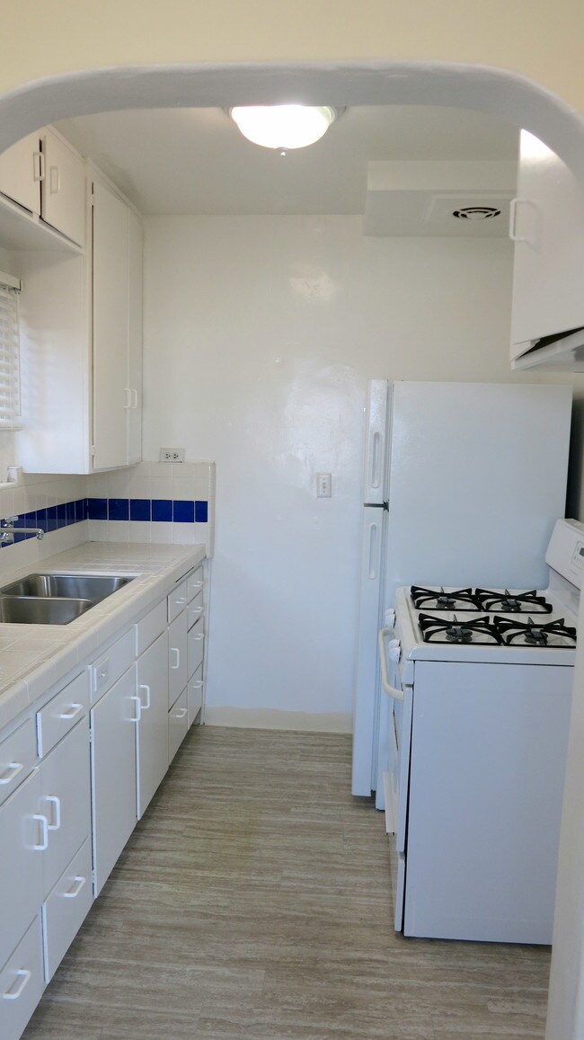 Cocina totalmente blanca con detalles en azul oscuro. - 3607 Crest Dr