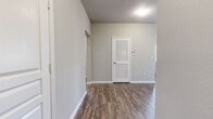 Located at 2650 Dade Ave in Orlando's 32804 zip code, this single-story, 3-bedroom, 4-bathroom home offers a well-organized layout with a thoughtful mix of finishes throughout. The open kitchen is a standout feature, equipped with stainless steel appliances including a refrigerator, range, microwave, and dishwasher, complemented by light wood cabinetry, granite countertops, a subway tile backsplash, and a central island — all set atop durable wood-style flooring. The combined kitchen and living area flows naturally, with large windows fitted with horizontal blinds that invite generous natural light. The living and common areas continue the wood-style flooring, while the bedrooms feature plush carpeting for added comfort. The spacious primary bedroom includes direct access to a closet and an en-suite bathroom. Additional bedrooms are well-sized with easy access to the remaining bathrooms, each finished with tile flooring and tub-shower combinations. A hallway connects the rooms efficiently, and two closets provide practical storage. The interior carries a clean, neutral palette with light gray walls, white trim, and textured ceilings, creating a bright and cohesive living environment throughout.