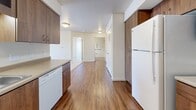 Located at 3500 S Sherman St in Englewood, Colorado, this two-bedroom, one-bathroom residence offers a practical and well-organized single-floor layout. The kitchen is a standout feature, equipped with rich walnut-toned cabinetry that extends to the ceiling for generous storage, a full suite of white appliances including a refrigerator, electric range, microwave, and dishwasher, and durable wood-style flooring. The kitchen opens directly to the living room, which transitions to plush carpeting and connects to a private balcony that brings in natural light and outdoor views. Both bedrooms are carpeted and feature sliding-door closets, offering comfortable and functional personal spaces. The second bedroom benefits from a large window framing open outdoor views. The full bathroom includes wood-style flooring, a bathtub with grab bars, and direct access to an adjacent closet with built-in wire shelving. Additional highlights include a dedicated laundry area, a welcoming entrance, and three closets throughout the unit for ample storage. The neutral color palette and clean finishes throughout give the space a bright, move-in-ready feel.