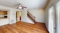 Located at 9706 Smoky Ridge Way in Knoxville, Tennessee, this two-story home offers a well-organized layout designed for comfortable everyday living. The main level welcomes you with rich hardwood flooring that flows throughout the open living area, which is anchored by a ceiling fan and bathed in natural light. A staircase with a classic wood banister and carpeted treads leads to the upper floor. The kitchen is positioned just off the living space and features warm wood cabinetry, granite-style countertops, stainless steel appliances including a refrigerator and microwave, and a convenient peninsula with a double sink — ideal for both meal prep and casual dining. French doors in one of the main-level rooms open to an outdoor area, adding versatility and additional natural light to the space. Upstairs, the bedrooms are finished with plush carpet and ceiling fans, providing a comfortable retreat. The primary bedroom includes access to a generously sized walk-in closet with wire shelving systems for ample storage. A full bathroom on this level features hardwood flooring, a tub-shower combination, and wood cabinetry with a granite-style vanity top, maintaining a consistent aesthetic throughout the home.