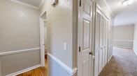 Located at 2160 N Thompson Ln in Murfreesboro, TN, this one-bedroom, one-bathroom unit offers a well-organized, single-floor layout designed for comfortable everyday living. The open living and dining area is finished with plush carpeting and neutral-toned walls accented by crown molding, creating a clean and inviting atmosphere. A set of French doors floods the space with natural light and opens directly onto a wooden deck, providing a seamless indoor-outdoor connection. The kitchen features warm wood cabinetry, a white refrigerator, a dishwasher, and a sink, all set against hardwood-style flooring that contrasts nicely with the carpeted living area. A connecting hallway with textured walls, classic white trim, and louvered closet doors leads to the private quarters. The bedroom is generously sized, carpeted, and equipped with a ceiling fan and a window that brings in additional natural light. A dedicated closet offers practical storage. The bathroom includes a full tub-shower combination with clean white finishes and hardwood-style flooring. Throughout the unit, consistent trim work, six-panel doors, and a cohesive neutral palette contribute to a tidy, well-maintained aesthetic.