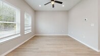 Located at 600 E Panther Way in Hewitt, TX, this single-story residence offers a thoughtfully designed layout that maximizes every square foot. Light wood-look flooring flows consistently throughout, creating a cohesive and bright aesthetic from room to room.

The open-concept kitchen and living area serves as the heart of the home. The kitchen is outfitted with crisp white shaker-style cabinetry, white quartz countertops, a subway tile backsplash, and stainless steel appliances including a range, built-in microwave, and French door refrigerator. A central island with pendant lighting above provides additional prep space and casual dining potential.

The bedroom is a well-proportioned retreat featuring a ceiling fan, recessed lighting, and windows with blinds that invite natural light. A dedicated closet with built-in shelving offers practical storage. The living area is similarly bright, with recessed lighting and a clean, neutral palette.

The bathroom is finished with a gray vanity, stone-look countertop, and a sleek frameless glass walk-in shower with dark marble-style tile surround — a standout feature that adds a touch of luxury. Clean white walls and light flooring keep the space feeling open and polished throughout.
