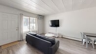 Located at 755 Burcham Dr in East Lansing, Michigan, this one-bedroom, one-bathroom unit offers a efficiently organized single-floor layout with clean, modern finishes throughout. Wood-look plank flooring flows seamlessly across all rooms, complemented by crisp white walls and a paneled ceiling that lends a cohesive, contemporary feel.

The combined kitchen and living area forms the heart of the unit. The kitchen is well-appointed with white shaker-style cabinetry, white subway tile backsplash, light countertops, and a full suite of stainless steel appliances including a range, over-the-range microwave, dishwasher, and refrigerator. The adjoining living room receives natural light through a street-facing window and includes a wall-mounted air conditioning unit and baseboard heating, providing year-round climate control.

The bedroom is a generously proportioned private retreat, featuring a window with blinds and a sliding-door closet, offering comfortable personal space. An additional flex area near the bedroom provides room for a home office setup.

The bathroom is clean and functional, finished entirely in white with a tub-shower combination, a white vanity with storage, and wood-look tile flooring. Throughout the unit, the design prioritizes simplicity and practicality, making it a well-suited space for individuals or students in the East Lansing area.