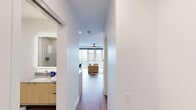Located at 945 Mid City Dr in Huntsville, Alabama, this modern studio offers a thoughtfully designed open-concept layout that efficiently combines living, sleeping, and dining areas into one cohesive space. Wide-format windows flood the living area with natural light and frame sweeping views of the surrounding Mid City neighborhood, complemented by a sleek ceiling fan overhead and warm hardwood-style flooring throughout.

The kitchen is well-appointed with light wood cabinetry, stainless steel appliances including a refrigerator, range, microwave, and dishwasher, and a tiled backsplash featuring a subtle geometric pattern. A stainless steel undermount sink, quartz-style countertops, and a stylish pendant light over an open shelving unit add both function and character to the space.

The bathroom is finished with large-format tile flooring, a glass-enclosed walk-in shower, and a wood-vanity with an undermount sink and backlit mirror, reflecting the same clean, contemporary aesthetic found throughout the unit. A dedicated closet provides practical storage.

Clean white walls, recessed lighting, and a consistent modern design language tie every area of this studio together, creating a bright, efficient, and visually cohesive living environment in the heart of Huntsville's vibrant Mid City district.