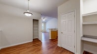 Located at 825 Beverley Dr in Charlottesville, VA, this well-appointed one-bedroom, one-bathroom residence offers a comfortable and functional layout across a single floor. Rich hardwood flooring flows throughout the main living areas, creating a warm and cohesive aesthetic. The living room is a standout space, anchored by a tile-surround fireplace with a classic mantel and complemented by a full-length entry door with transom window that ushers in generous natural light. A ceiling fan adds practical comfort overhead. The kitchen is open and efficient, featuring light wood cabinetry, ample upper and lower storage, white countertops, and a full suite of stainless steel appliances including a range, dishwasher, and refrigerator. A peninsula with a sink connects the kitchen to the living area, offering a convenient pass-through design. The spacious bedroom is finished with plush carpet, crown molding, a ceiling fan, and a bright window overlooking the exterior. A dedicated closet with built-in shelving provides excellent storage. The bathroom includes a wood vanity, white countertop, and a full tub-shower combination with tile surround. A separate laundry area with wire shelving above rounds out the practical amenities of this thoughtfully designed residence.