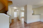 Located on Peter's Landing Lane in Marysville, WA, this two-story home offers a thoughtfully designed layout across two floors. The main level features warm hardwood-style flooring throughout the open-concept living and kitchen area. The kitchen is equipped with white shaker cabinetry, stainless steel appliances including a range, microwave, and dishwasher, complemented by grey countertops and a functional layout. The living room benefits from a large window that allows generous natural light to fill the space, and a staircase leads to the upper level. A bathroom on the main floor provides added convenience.

Upstairs, plush carpeting runs throughout the hallway landing and bedrooms. The upper floor hosts all three bedrooms, each featuring carpeted floors, neutral-toned walls, and windows with outdoor views. The generously sized primary bedroom includes its own closet and en-suite access. Two additional bedrooms share the remaining bathrooms, each fitted with vanities and hardwood-style flooring. A utility room adds functional storage to the home. Throughout, the space maintains a clean, neutral palette with cream-toned walls, creating a bright and welcoming atmosphere well-suited for comfortable everyday living.