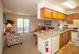 Located at 4816 McMahon Blvd NW in Albuquerque, New Mexico, this single-floor residence offers a well-designed layout that balances functionality and comfort. The open-concept kitchen and living area form the heart of the home, creating a seamless flow between spaces. The kitchen is outfitted with warm wood cabinetry, a gas range, a full-size refrigerator, a double-basin sink, and light-toned countertops. A peninsula with bar seating provides an ideal spot for casual dining and connects naturally to the living area. The living room is carpeted and bathed in natural light, thanks to a large sliding glass door that opens to a private balcony overlooking lush greenery — a standout feature that brings the outdoors in. The bedroom is a serene retreat, featuring plush carpeting, a mirrored sliding closet, and a bright window that fills the room with natural light. The bathroom is thoughtfully appointed with a wood-framed vanity, stone-toned countertop, and hardwood-style flooring. Throughout the residence, a neutral color palette and textured ceilings contribute to a warm, inviting ambiance that is both practical and comfortable.