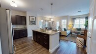 Located at 380 Mather St in Hamden, Connecticut, this single-floor residence offers a thoughtfully designed open-concept layout that seamlessly connects the kitchen, dining, and living areas. The kitchen is a standout feature, showcasing rich dark cabinetry, granite countertops, stainless steel appliances including a gas range and refrigerator, and a central island with bar seating illuminated by pendant lighting — ideal for both cooking and casual dining. Adjacent to the kitchen, a dedicated dining nook is distinguished by bold botanical wallpaper, a large grid-style mirror, and an elegant chandelier, creating an intimate yet stylish atmosphere. The living room offers a warm, inviting ambiance with soft sage-green walls, large windows that invite abundant natural light and outdoor views, and hardwood-style flooring that flows throughout the space. The bedroom is a serene retreat featuring calming neutral tones, multiple windows with views of the surrounding greenery, and access to a closet and en-suite bath. The bathroom is finished with a dual-sink dark wood vanity, framed mirrors, and neutral tile flooring. An in-unit laundry area adds everyday convenience to this well-appointed residence.