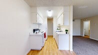 This single-floor, 2-bedroom, 2-bathroom residence in Carmichael, California offers a functional and comfortable layout designed to maximize every square foot of living space. The galley-style kitchen is bright and efficient, featuring white cabinetry, light-toned countertops, a full suite of white appliances including an electric range and refrigerator, and a double sink. Warm hardwood-style flooring runs throughout the kitchen, which opens conveniently toward the main living area. The living room is generously proportioned, featuring plush carpeting, neutral walls, a textured ceiling, and a large window with vertical blinds that allows abundant natural light to fill the room. A front entry door provides direct access to this welcoming space. Both bedrooms are carpeted and offer comfortable dimensions, with the primary bedroom including a sliding-door closet and direct access to one of the two bathrooms. The second bedroom also benefits from natural light via a window with vertical blinds. A dedicated walk-in closet provides additional storage, complemented by two other closets throughout the unit. The bathrooms include a tub-shower combination with hardwood-style flooring. A connecting hallway ties the layout together seamlessly, making this a practical and well-appointed home.