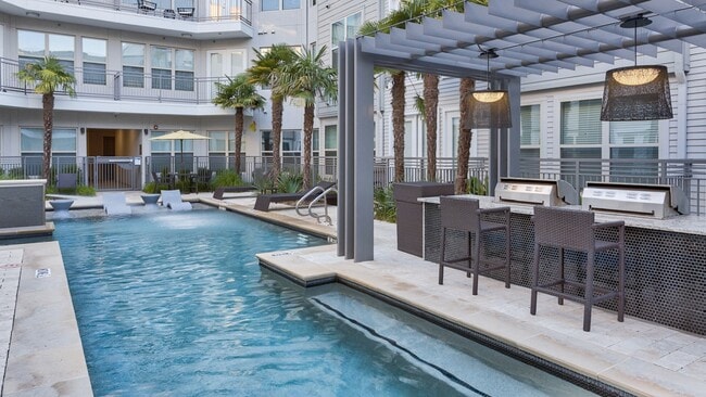 La estación de parrilla junto a la piscina y la isla de comedor crean un excelente lugar para entretener a amigos y familiares. - Windsor West Lemmon