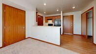 Located at 1414 41st Ave in Alexandria, MN, this single-floor residence offers a clean, functional layout designed for comfortable everyday living. The open-concept kitchen is a central highlight, featuring warm wood cabinetry, a peninsula counter with a double sink, light hardwood-style flooring, black appliances including a refrigerator and range, and a dedicated pantry for ample storage. Recessed lighting illuminates the space, which flows seamlessly into the adjacent living area finished with plush carpeting and rich wood baseboards and door trim throughout.

The bedrooms are generously sized, each bathed in natural light from large windows that offer views of the surrounding community. One bedroom includes a sliding-door closet with built-in shelving, providing practical storage. A glass-panel door leads to a private balcony, extending the living space outdoors with an open railing and pleasant exterior views.

The bathroom is finished with warm-toned tile flooring, a wood-cabinet vanity with a framed mirror, and a well-lit fixture overhead. Throughout the residence, consistent warm wood accents on doors, trim, and cabinetry create a cohesive and inviting aesthetic. The overall ambiance is bright, clean, and move-in ready.