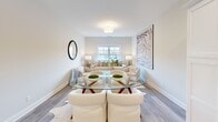 Located on Canal Street in Shelton, Connecticut, this one-bedroom, one-bathroom unit offers a thoughtfully designed single-floor layout that maximizes its compact footprint. The open-plan kitchen and living area forms the heart of the unit, creating a cohesive and functional shared space. The kitchen is outfitted with bright white shaker-style cabinetry, light quartz countertops, a white subway tile backsplash, and a full suite of stainless steel appliances, including a refrigerator, range, built-in microwave, and dishwasher. Light wood-tone luxury vinyl plank flooring flows throughout, contributing to the clean, contemporary aesthetic.

The living area accommodates a comfortable seating and dining arrangement, with a window providing natural light and an open feel. Neutral wall tones enhance the airy ambiance throughout.

The bedroom is generously proportioned, featuring a double-door closet, a window with natural light, and soft carpeting. The calm, neutral palette creates a restful atmosphere.

The bathroom includes a walk-in glass-door shower with built-in shelving and brushed nickel fixtures, finished in a clean, minimalist style. A hallway connects the main living spaces, completing the efficient and well-organized floor plan.