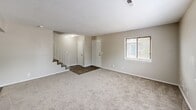 Located at 411 E Marion Rd in Wichita, Kansas, this two-story home offers three bedrooms and three bathrooms thoughtfully distributed across two floors. The main level features a combined kitchen and living area with durable hardwood-style flooring. The kitchen is equipped with warm oak cabinetry, a white appliance suite including a range, dishwasher, and refrigerator, along with a double sink and a pass-through window that connects to the living area, enhancing the open feel. The living room is carpeted and bathed in natural light from a large window, with a staircase featuring white metal railings leading to the upper floor. A bathroom on the main level includes a wood-framed vanity mirror and tile backsplash. Upstairs, three carpeted bedrooms each feature natural light from windows. The primary bedroom offers mirrored sliding closet doors, while the secondary bedrooms include standard closet storage. The upper-level bathroom is finished with a marble-patterned granite vanity, white cabinetry, and hardwood-style flooring. A textured ceiling is consistent throughout the home, adding a classic residential character. The layout is efficient and well-organized, making this a functional and comfortable multi-story home.