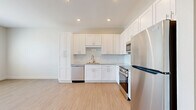 Located in Bradenton, Florida, this one-bedroom unit offers a clean, modern design across a single floor. The open-concept layout allows the kitchen and living area to flow seamlessly together, creating an efficient and inviting space. Light wood-style flooring runs throughout, complementing the neutral white walls and contributing to a bright, airy ambiance.

The kitchen is a standout feature, outfitted with white shaker-style cabinetry extending to the ceiling for generous storage, granite countertops, a white tile backsplash, and a full suite of stainless steel appliances including a refrigerator, range, built-in microwave, and dishwasher. Recessed lighting illuminates the kitchen area, adding a polished touch. A tall pantry-style cabinet provides additional storage.

The bedroom is a comfortable, well-proportioned room featuring a ceiling fan, a window with blinds that allows natural light to filter in, and the same light flooring found throughout. A dedicated closet offers practical storage. The space maintains a consistent, contemporary aesthetic with clean lines, white trim, and neutral tones throughout, making it a versatile and move-in-ready unit in the heart of Bradenton.