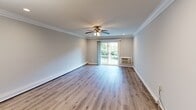Located at 721 Greenbrier Drive in Bohemia, NY, this single-floor residence at Fairfield Sunrise Gardens combines modern updates with a clean, functional design throughout. The open living and dining area is a standout feature, showcasing light-toned hardwood-style flooring, crown molding, recessed lighting, and a ceiling fan. A large sliding glass door fills the space with natural light and provides views of the outdoor surroundings, while a chandelier adds a touch of elegance to the dining area. The hallway, accented with crown molding and flush ceiling lighting, connects the main living areas to the private rooms seamlessly. The kitchen is well-equipped with warm wood cabinetry, dark granite countertops, a stainless steel refrigerator, stainless range and microwave, and a dishwasher. A pantry with open shelving provides additional storage, and a window above the range area brings in natural light. The bedrooms are generously sized, each featuring ceiling fans, crown molding, hardwood-style flooring, and ample closet space with built-in shelving and hanging rods. Wall-unit climate control is present in the bedrooms and living area, ensuring year-round comfort. The overall aesthetic is bright, neutral, and move-in ready.