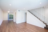 Located at 2511 Grove Way in Castro Valley, CA, this two-story, 2-bedroom, 3-bathroom home offers a practical and well-appointed layout spread evenly across two floors. The main level features a bright living room with warm wood-look flooring, recessed lighting, and a front-facing window that invites natural light. The kitchen is equipped with rich wood cabinetry, granite-style countertops, stainless steel appliances including a refrigerator and range, and a sliding door providing outdoor access. A dedicated laundry room on this level houses a full-size top-loading GE washer and dryer. Upstairs, both bedrooms are finished with plush wall-to-wall carpeting and include closets with sliding doors. The spacious primary bedroom features a large window dressed with vertical blinds. A connecting hallway lined with stone tile flooring leads to the bathrooms, one of which showcases classic white subway tile surrounding a soaking tub with chrome fixtures. Throughout the home, clean white walls, recessed lighting, and consistent finishes create a cohesive, move-in ready aesthetic suited for comfortable everyday living.