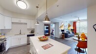 Located at 4209 Lassiter Mill Rd in Raleigh, NC, this well-appointed single-floor residence offers a thoughtfully designed layout with modern finishes and a cohesive aesthetic throughout. The open-concept kitchen is a standout feature, showcasing white shaker cabinetry, subway tile backsplash, stainless steel appliances, and a generously sized island with quartz countertops illuminated by brushed nickel pendant lights. The kitchen flows seamlessly into the living area, creating an ideal space for entertaining. Wood-look plank flooring extends throughout the main living areas, adding warmth and continuity. The multiple bedrooms are well-proportioned, each benefiting from large windows that invite natural light and offer views of the surrounding greenery. Crown molding and ceiling fans are present in the bedrooms, lending a polished feel. The bathrooms are clean and functional, featuring white vanities with quartz countertops and tub-shower combinations. The overall design palette is neutral and contemporary, complemented by vibrant accent decor. This residence combines practical design with comfortable living in a prime Raleigh location.
