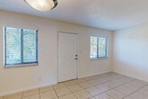 Located at 1850 NE 48th St in Pompano Beach, Florida, this two-bedroom, two-bathroom single-floor unit offers a practical and well-organized layout. Light-toned tile flooring runs consistently throughout the entire space, creating a cohesive and easy-to-maintain interior. The combined living and dining area serves as the heart of the home, filled with natural light from multiple windows fitted with blinds. A front entry door flanked by windows gives the space a bright, welcoming feel. The kitchen is equipped with warm-toned wooden cabinetry, dark granite countertops, a stainless steel sink, and white appliances including a refrigerator and dishwasher, complemented by a window that brings in additional natural light. Both bedrooms are comfortably sized, with the primary bedroom offering generous proportions and its own walk-in closet accessed through louvered doors. In total, four closets are distributed throughout the unit, providing ample storage. The two bathrooms are finished in a clean, all-white palette, each featuring a tub-shower combination, vanity, and tile flooring. Textured ceilings and flush-mount light fixtures are consistent throughout, contributing to the unit's tidy, understated aesthetic well-suited to the sunny South Florida climate.