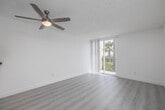 Located at 860 W Fifth Street in San Pedro, Los Angeles, this well-appointed 1-bedroom residence spans two floors, offering a thoughtful layout with generous living space distributed across both levels. The interior is defined by a clean, modern aesthetic — crisp white walls, light wood-look flooring, and textured ceilings combine to create a bright and airy atmosphere throughout.

The main floor hosts an open-concept kitchen and living room, where the kitchen features white cabinetry, granite-style countertops, a stainless steel sink, and black appliances including a range and refrigerator. A peninsula counter separates the kitchen from the living area, and a ceiling fan overhead enhances airflow and comfort. Sliding glass doors lead to one of two balconies, where sweeping views of lush palm trees and the surrounding San Pedro neighborhood await.

The bedroom is a well-proportioned, light-filled retreat with its own balcony access via a sliding glass door, a ceiling fan, and a dedicated closet. The second floor provides additional living area, contributing to the overall sense of spaciousness within the home.

Two balconies offer elevated outdoor space with verdant, palm-lined views under Southern California's abundant sunshine — an ideal setting for enjoying the temperate Los Angeles coastal climate year-round.