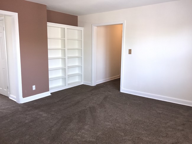 Living Room w/Book shelf - Hillcrest Village Apartments