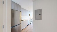 Located at 2800 SW 27th Terrace in Miami's vibrant Coconut Grove neighborhood, this efficiently designed studio offers a thoughtful layout across a single floor, maximizing every inch of its intimate footprint. The open-concept living area is anchored by floor-to-ceiling sliding glass doors that flood the space with natural light and frame sweeping panoramic views of the Miami skyline. A white-painted brick accent wall adds texture and warmth, complementing the light hardwood flooring found throughout. A built-in Murphy bed with integrated shelving and a sofa seamlessly transitions the living area from day to night use, making the most of the space. The galley-style kitchen is outfitted with light wood cabinetry extending to the ceiling, white quartz countertops, a stainless steel undermount sink, a dishwasher, and a full-size refrigerator, offering a clean, contemporary aesthetic. The bathroom features a minimalist design with large-format tile flooring, a glass-enclosed shower, a wall-mounted vanity with a white quartz countertop, an undermount sink, and a wide mirror. A dedicated closet provides convenient storage. The overall ambiance is bright, modern, and airy, perfectly suited for urban living in one of Miami's most sought-after neighborhoods.