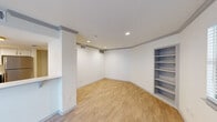 Located in the heart of downtown Austin at 205 E 4th St, this one-bedroom, one-bathroom unit offers a well-designed single-floor layout that maximizes every square foot. Light-toned wood-look flooring runs throughout, lending warmth and visual continuity across all rooms.

The combined kitchen and living area serves as the hub of the unit. The kitchen is outfitted with striking navy-blue lower cabinetry, white upper cabinets, and crisp white countertops. A full suite of stainless steel appliances — including a refrigerator, range, microwave, and dishwasher — provides a modern, functional cooking space. A window above the sink allows natural light to filter in. The adjacent living area features built-in shelving, recessed lighting, and a front entry door flanked by windows that bring in additional natural light.

The spacious primary bedroom is a comfortable retreat, highlighted by a ceiling fan with a wood-toned blade, a window with blinds, and continued wood-look flooring. A dedicated closet offers practical storage.

The bathroom is finished with matte black fixtures, a tub/shower combo with white subway tile surround, a navy vanity with white countertop, and a round mirror — a cohesive design that echoes the unit's overall modern aesthetic.