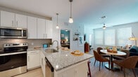 Located at 2260 Ringling Blvd in Sarasota, Florida, this single-floor residence combines contemporary design with thoughtful functionality. The open-concept layout connects the kitchen, dining, and living areas seamlessly, creating an inviting flow throughout the space. Light wood-style flooring runs continuously underfoot, enhancing the bright, airy atmosphere.

The kitchen is a standout feature, equipped with crisp white cabinetry, granite countertops, a subway tile backsplash, and a full suite of stainless steel appliances including a refrigerator, range, and microwave. A central island with seating provides both additional prep space and a casual dining option, with pendant lighting above.

The living room is well-lit by multiple windows dressed with white blinds that allow natural light to filter in. A bold accent wall with textured wallcovering adds visual interest, complementing the ceiling fan overhead.

The primary bedroom features a teal accent wall, large windows, light wood flooring, and a ceiling fan, creating a calm and comfortable retreat. A second bedroom offers neutral tones, dual windows, and ample natural light.

The bathroom is finished with a granite-topped wood vanity, wide mirror, and light wood-style flooring, offering a clean and functional design. Overall, this residence presents a cohesive modern aesthetic with quality finishes throughout.