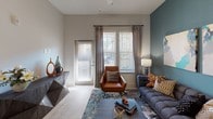 This single-story residence in Fort Mill, South Carolina, presents a thoughtfully designed interior that balances modern aesthetics with everyday functionality. The open-concept layout connects the living, dining, and kitchen areas seamlessly, creating a cohesive and airy feel throughout the main living space.

The kitchen is a standout feature, showcasing floor-to-ceiling wood-grain cabinetry in a warm gray tone, granite countertops, a full suite of stainless steel appliances, and a central island with bar seating illuminated by pendant lighting. Light wood-style flooring runs through the main areas, enhancing the bright, contemporary atmosphere.

The living room is highlighted by a bold teal accent wall, large windows with blinds and draping curtains, and a glass door providing outdoor access and ample natural light. Multiple bedrooms each offer plush carpeting, generous natural light from large windows, and walk-in closet access. Accent walls in rich tones add warmth and character to each room.

The bathrooms feature light wood-style flooring, granite vanity tops, dark cabinetry, and tile-surround tub-shower combinations. A half bath provides added convenience. Overall, the space delivers a polished, contemporary living environment.