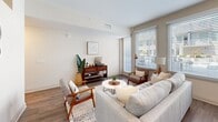 Located at 10 Westedge Street in Charleston, South Carolina, this one-bedroom, one-bathroom residence offers a thoughtfully designed layout that maximizes every square foot. A clean, well-lit hallway with hardwood-style flooring and crisp white walls welcomes you into the space, setting a bright and modern tone throughout.

The combined kitchen and living area serves as the heart of the home. The kitchen features white shaker-style cabinetry, light quartz countertops, a subway tile backsplash, and a full suite of stainless steel appliances including a range, over-the-range microwave, and refrigerator. The living area flows naturally from the kitchen and is bathed in natural light through a wall of large windows and a glass door that opens to an outdoor space, creating an airy, open ambiance.

The bedroom is a comfortable and cozy retreat, featuring a ceiling fan, a built-in closet with double doors, and a distinctive elevated window detail that brings in additional natural light while maintaining privacy.

The bathroom is well-appointed with a shower-tub combination, a grey vanity with white countertops, and light tile flooring. A standout feature is the in-unit stacked washer and dryer conveniently located within the bathroom area. A hallway closet provides additional storage, rounding out this efficiently designed Charleston residence.