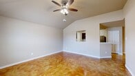 This single-story home offers a thoughtfully designed layout across three bedrooms and two bathrooms. A defining characteristic throughout the living areas, bedrooms, and bathrooms is the rich, amber-toned stained concrete flooring, which lends a warm and unique aesthetic to the interior.

The open living room features vaulted ceilings and a ceiling fan, creating an airy and spacious feel. A pass-through window connects the living area to the kitchen, enhancing the open flow of the home. The kitchen is well-equipped with dark espresso cabinetry, granite-style countertops, stainless steel appliances including a refrigerator, range, and microwave, and a convenient breakfast bar.

The primary bedroom includes vaulted ceilings, a ceiling fan, a window for natural light, and direct access to an en-suite bathroom and a dedicated closet. The additional bedrooms are comfortable and well-lit with natural light from windows. Both bathrooms feature clean, functional finishes with tub-shower combinations and dark wood vanities.

Additional highlights include two closets for ample storage, a hallway connecting the main rooms, and an attached single-car garage with an automatic opener. The home's consistent stained concrete flooring and neutral wall tones create a cohesive and modern interior throughout.