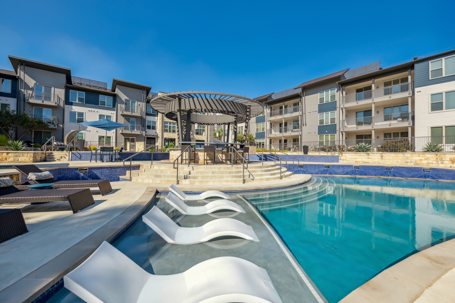 Resort-style pool with tanning shelf - The Addison Apartments