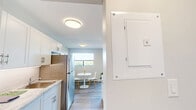 Located at 840 Trillium Park in Sarnia, Ontario, this well-appointed one-bedroom, one-bathroom unit offers a thoughtfully designed open-concept layout finished with light hardwood-style flooring throughout. The kitchen is a standout feature, showcasing crisp white cabinetry with gold-toned hardware, a striking marble-effect countertop that extends to a peninsula breakfast bar, white subway tile backsplash, and stainless steel appliances including a full-size refrigerator and gas range. The kitchen flows seamlessly into the living area, which is bathed in natural light from large windows and a sliding glass door opening onto a private balcony with expansive outdoor views — an ideal setting for relaxing or entertaining. The bedroom is a comfortable and serene retreat, offering a well-sized closet and a bright window that allows natural light to fill the room, complemented by the same warm flooring found throughout. The bathroom is clean and functional, featuring a full soaker tub and shower combination with bright white tile surround and chrome fixtures. The overall ambiance of the unit is modern, light, and airy, with a neutral colour palette that creates a welcoming and versatile living environment.